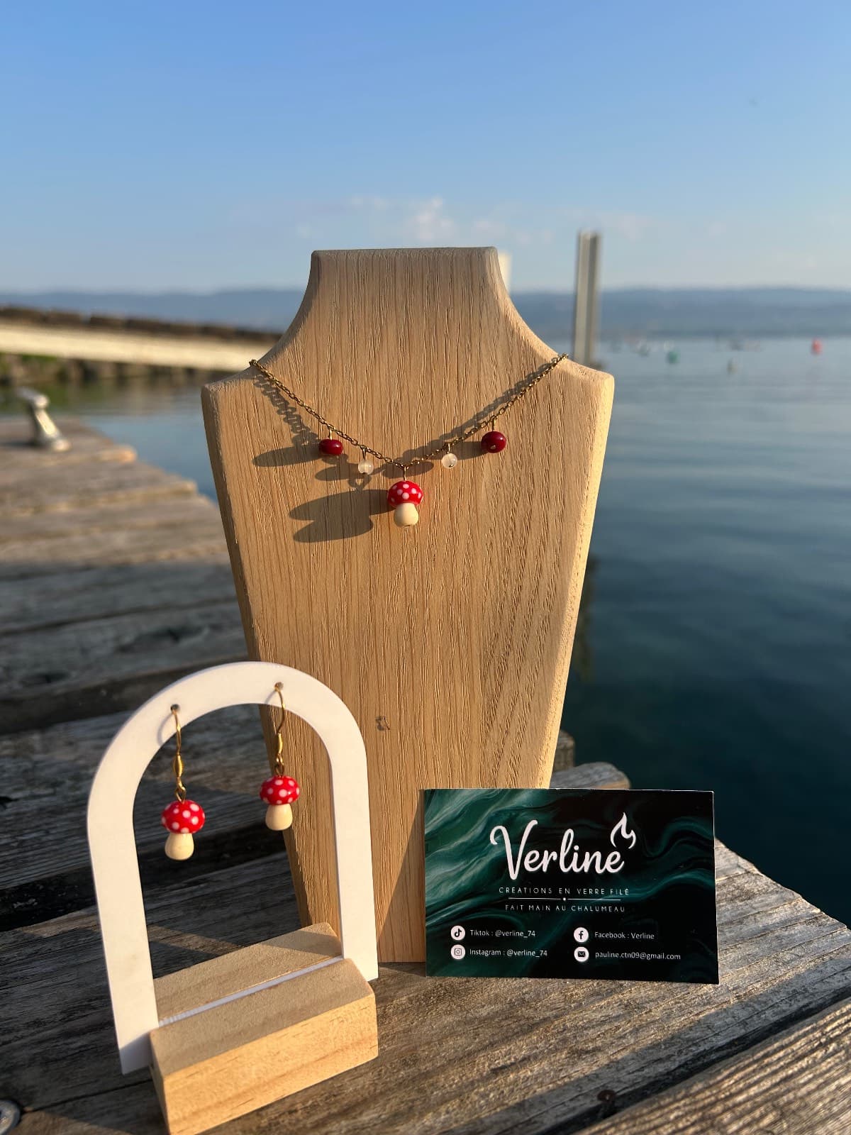 Vue de trois-quarts des boucles d'oreilles champignons rouges et blancs suspendues à une arche blanche.