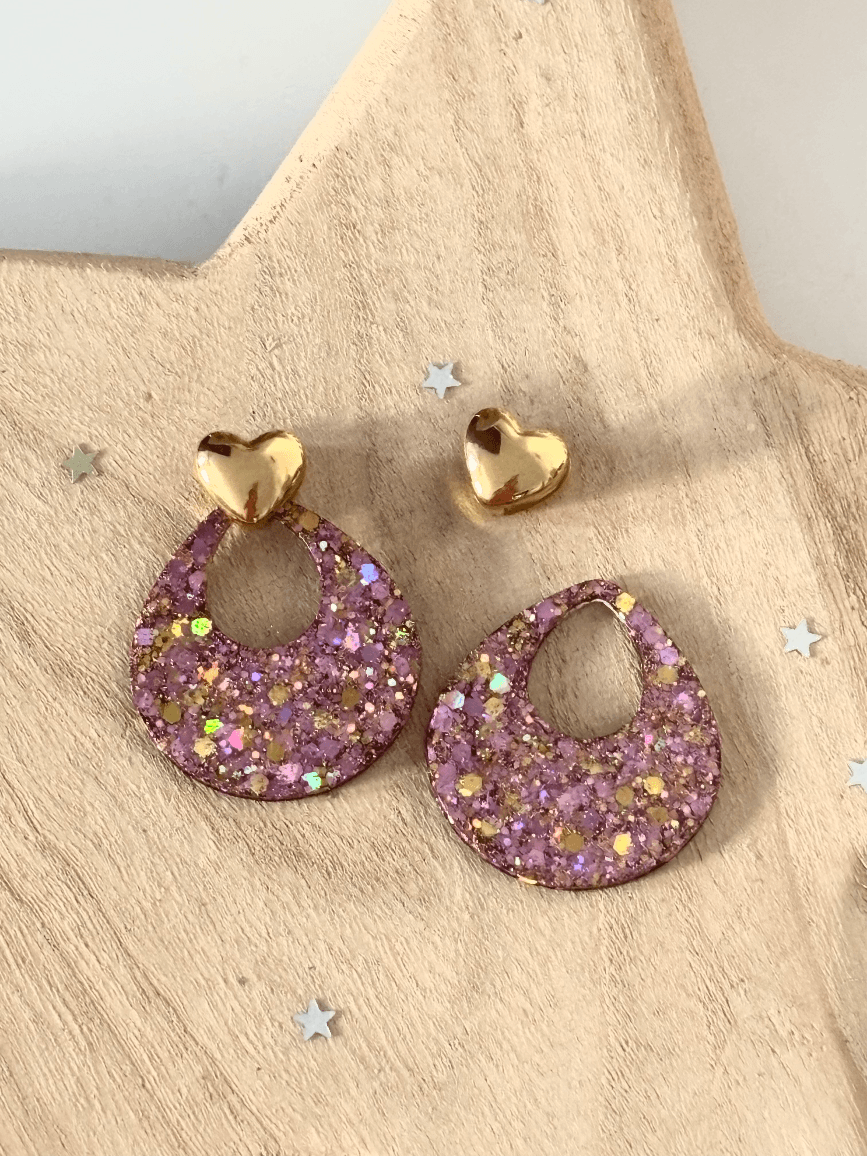 Boucles d'oreilles modulables présentant un cœur doré assemblé et un détaché de sa pampille rose