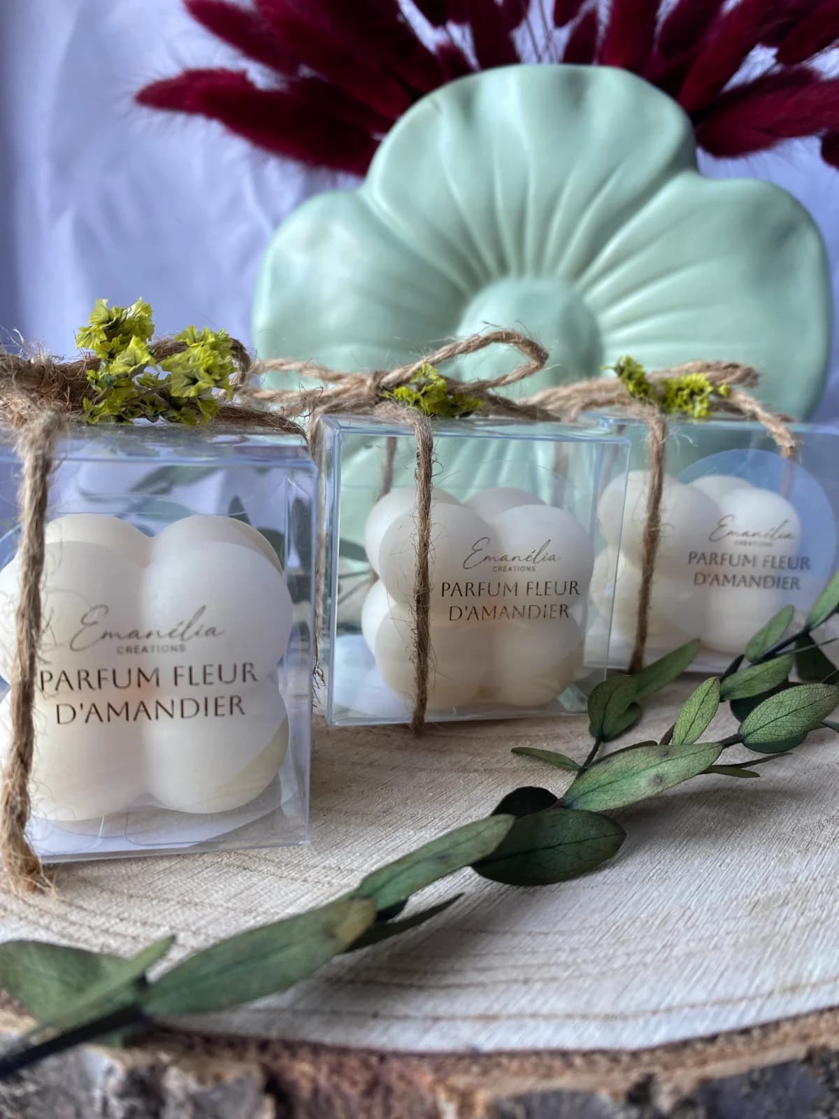 Gros plan sur les boîtes transparentes décorées d'une touche florale contenant des fondants parfumés blancs.