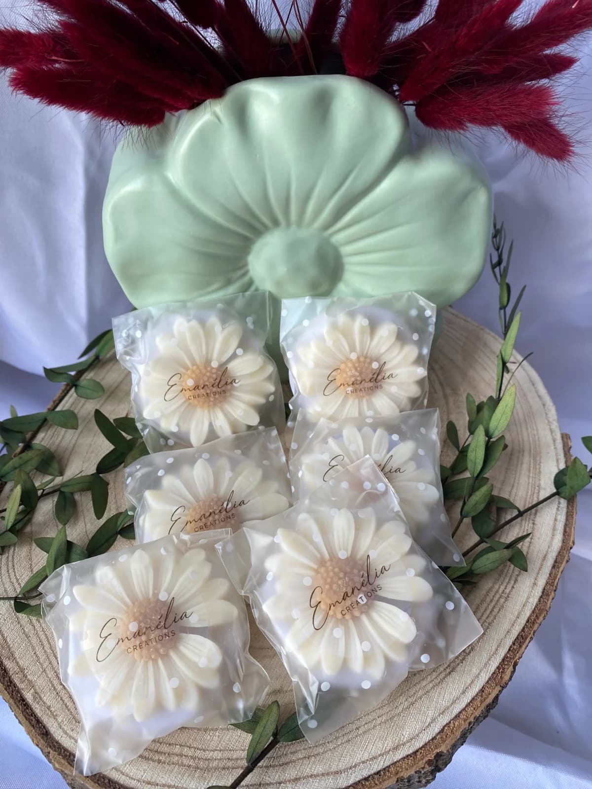 Gros plan sur les fondants parfumés sculptés en marguerites dans leurs sachets individuels à pois.